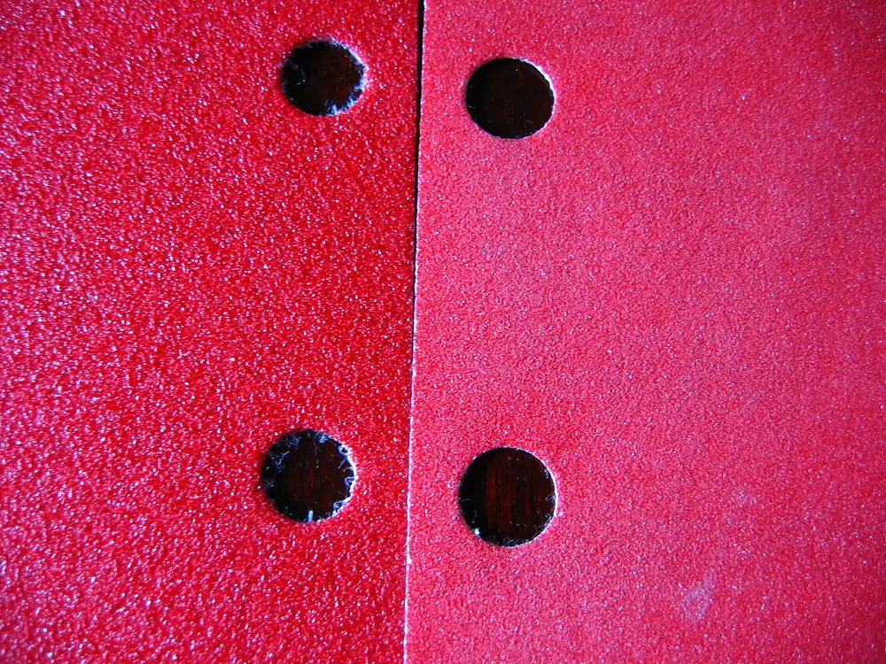 Close-up of two sheets of sandpaper, a coarser grit on the left and a finer grit on the right