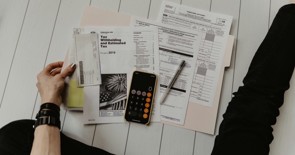 Tax documents, IRS forms, and calculator on white wooden desk representing HVAC tax credit planning